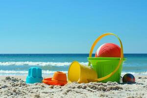 Kinder- Spielzeuge Lüge auf das Sand. klein Meer Wellen sind sichtbar im das Hintergrund. Sommer- sich ausruhen foto