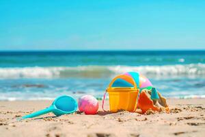 Kinder- Spielzeuge Lüge auf das Sand. klein Meer Wellen sind sichtbar im das Hintergrund. Sommer- sich ausruhen foto