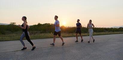 ein vielfältig Gruppe von Läufer Züge zusammen beim Sonnenuntergang. foto