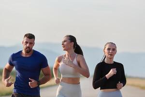 ein Gruppe von freunde pflegt ein gesund Lebensstil durch Laufen draußen auf ein sonnig Tag, Verbindung Über Fitness und genießen das energetisierend Auswirkungen von Übung und Natur foto