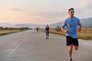 ein Gruppe von freunde pflegt ein gesund Lebensstil durch Laufen draußen auf ein sonnig Tag, Verbindung Über Fitness und genießen das energetisierend Auswirkungen von Übung und Natur foto