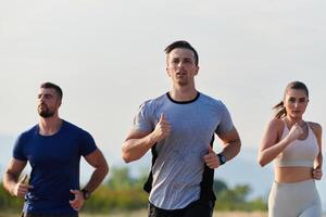 ein Gruppe von freunde pflegt ein gesund Lebensstil durch Laufen draußen auf ein sonnig Tag, Verbindung Über Fitness und genießen das energetisierend Auswirkungen von Übung und Natur foto