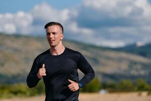 sportlich Mann Joggen im das Sonne, vorbereiten seine Körper zum Leben extrem Herausforderungen foto