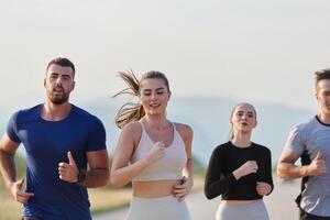 ein Gruppe von freunde pflegt ein gesund Lebensstil durch Laufen draußen auf ein sonnig Tag, Verbindung Über Fitness und genießen das energetisierend Auswirkungen von Übung und Natur foto