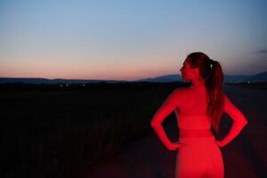 Athlet Streiks ein Pose im rot beleuchtet Nachtzeit glühen foto