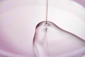 Serum oder kosmetisch Öl fließt in ein transparent Schüssel auf ein lila Hintergrund. foto