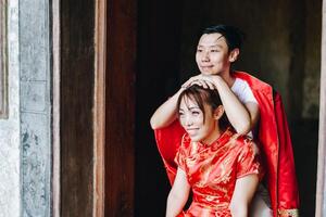 glückliches junges asiatisches paar in chinesischen traditionellen kleidern foto