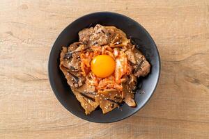 Schweinefleisch-Bulgogi-Reisschüssel mit Kimchi und koreanischem eingelegtem Ei foto
