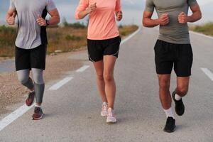 ein Gruppe von Freunde, Sportler, und Jogger Umarmung das früh Morgen Std wie Sie Lauf durch das neblig Dämmerung, erregt durch das steigend Sonne und umgeben durch das still Schönheit von Natur foto