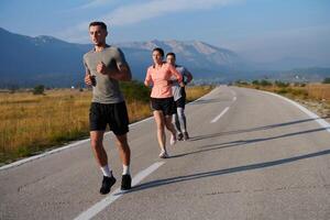 ein Gruppe von freunde pflegt ein gesund Lebensstil durch Laufen draußen auf ein sonnig Tag, Verbindung Über Fitness und genießen das energetisierend Auswirkungen von Übung und Natur foto