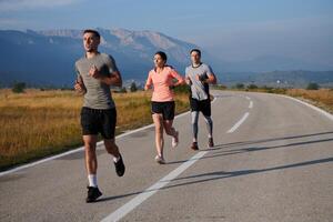 ein Gruppe von freunde pflegt ein gesund Lebensstil durch Laufen draußen auf ein sonnig Tag, Verbindung Über Fitness und genießen das energetisierend Auswirkungen von Übung und Natur foto