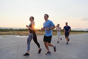 ein vielfältig Gruppe von Läufer Züge zusammen beim Sonnenuntergang. foto