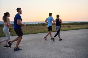 ein vielfältig Gruppe von Läufer Züge zusammen beim Sonnenuntergang. foto