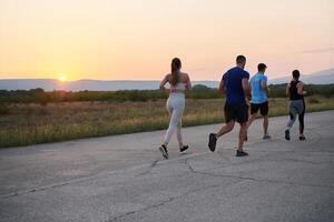 ein vielfältig Gruppe von Läufer Züge zusammen beim Sonnenuntergang. foto