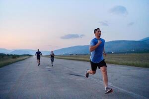 ein Gruppe von freunde pflegt ein gesund Lebensstil durch Laufen draußen auf ein sonnig Tag, Verbindung Über Fitness und genießen das energetisierend Auswirkungen von Übung und Natur foto