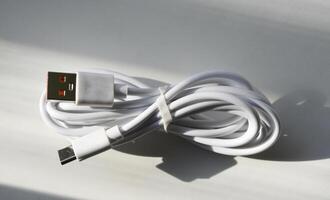 USB Kabel auf ein Weiß Hintergrund. ein Weiß prod zum das Telefon. foto