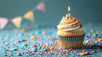 Cupcake mit Kerze und Sträusel auf Blau Hintergrund foto