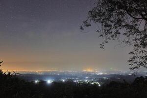 Aussicht von Stadt Beleuchtung beim Nacht gesehen von das oben von das Hügel foto