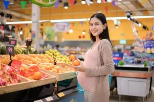 schön schwanger Frau Einkaufen gesund Essen beim Lebensmittelgeschäft Geschäft foto