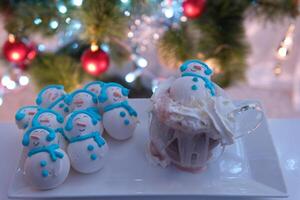 Hinzufügen Sahne im Kakao Glas Glas in der Nähe von das Weihnachten Baum zum Weihnachten Baiser Schneemann köstlich Essen Unterhaltung Kochen Neu Jahr Feier foto