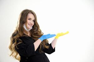 ein weiblich Arzt im ein schwarz passen mit fließend Haar mit ein Maske gesenkt zu ihr Kinn Punkte mit ihr Hand zu ein leeren Raum zum Werbung Text Blau und Gelb hygienisch Handschuh Studio Weiß Hintergrund foto