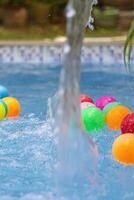 bunt Bälle im ein Schwimmbad mit planschen Wasser foto