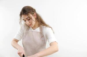 ein jung Mädchen gebogen Über schneidet etwas Nahansicht das Gesicht von ein gelehnt Mann im ein Schürze das Koch bereitet vor Kochen im das Küche im ein Schürze ein Weiß T-Shirt auf ein Weiß Hintergrund Werbung foto
