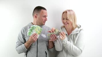 ein mittleren Alters Ehefrau fragt ihr Mann zum Geld zu Kaufen Dollar und Euro, das Mann nimmt ein Teil von Es, das Ehefrau zählt Geld, viele anders Emotionen, Gespräche, ein Kuss foto