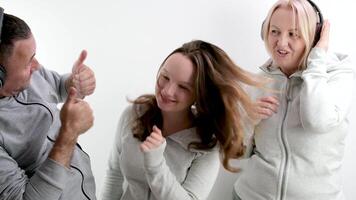 gut positiv-psychologisch Beziehungen im das Familie die Genehmigung Teenager Mädchen Tanzen auf ein Weiß Hintergrund im Kopfhörer das Mädchen zeigt an das Bewegung von das Eltern erziehen ihr Daumen oben Sie mögen foto