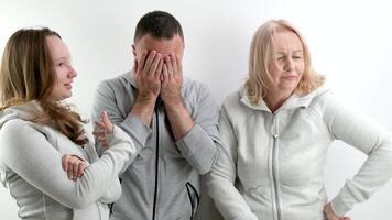 Familie Streit Frauen gegen Männer zwei Mädchen Mutter und Tochter schelten Vater Welle Hände Mann Abdeckungen seine Gesicht im Grusel Schlecht Beziehung Showdown foto