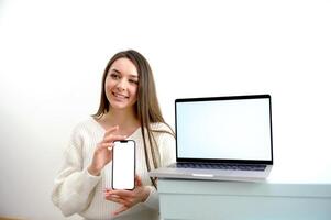 ein Krankenschwester mit ein Telefon im ihr Hände ist Tippen ein Text Botschaft im das Vordergrund ein Laptop mit ein Weiß Chroma Schlüssel Bildschirm leeren Raum zum Text foto