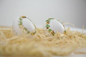 Ostern Eier und Gänseblümchen im das Gras Verpackung Papier verschönert gestickt trocken Gras foto