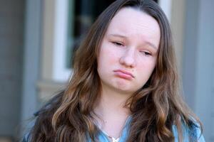 traurig Gesicht von ein Teenager Mädchen unzufrieden verärgert traurig Streit mit freunde brechen oben mit ein Freund krank beim Schule Probleme Probleme psychologisch Hilfe zum Kinder jung Frau Traurigkeit im das Augen foto