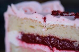 Essen Käsekuchen mit ein Gabel. nehmen beißen von Käsekuchen. Süss Dessert Essen schließen oben von ein Rosa Erdbeere Kuchen wirbelnd auf ein Weiß Platte. foto