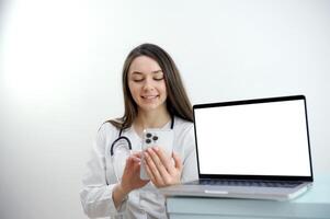 Frau Arzt Arbeiten auf das Telefon antworten das Anruf im Vorderseite von ihr Laptop mit Weiß Bildschirm Raum zum Werbung freundlich weiblich Arzt Über Weiß Hintergrund mit ein Laptop foto