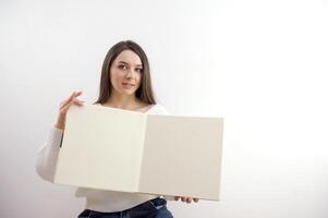Porträt von ein jung Frau mit leer Plakatwand isoliert auf Weiß Hintergrund foto
