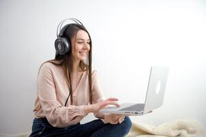 schön jung Frau Aufpassen ein Film auf Laptop foto