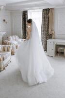 ein Frau im ein Weiß Hochzeit Kleid ist Stehen im Vorderseite von ein Schreibtisch foto