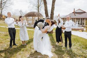 ein Gruppe von Menschen sind posieren zum ein Bild, mit ein Braut und Bräutigam im das Center foto