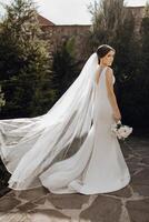 ein Frau im ein Weiß Hochzeit Kleid ist Stehen im Vorderseite von ein Backstein Mauer foto