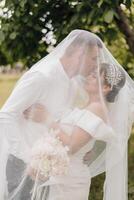 ein Braut und Bräutigam sind Umarmen unter ein Schleier foto