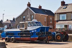 Angeln Boot und Traktor im Wohn Bereich im neubiggin-by-the-sea Strand foto