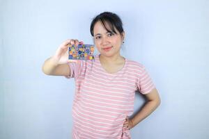 lächelnd Gesicht Ausdruck von schön asiatisch jung Frau zeigen Anerkennung Karte auf Weiß Hintergrund foto