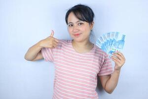 Porträt von ein jung asiatisch Frau halten Kasse während geben ein Daumen hoch. Werbung Konzept foto