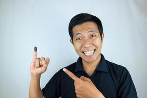 lächelnd indonesisch Mann zeigen wenig Finger nach Wählen auf Indonesiens Präsidentschaftswahl Wahl foto