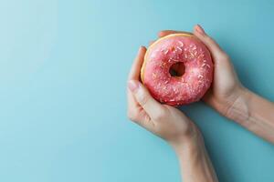 Person halten Rosa Krapfen mit Sträusel foto