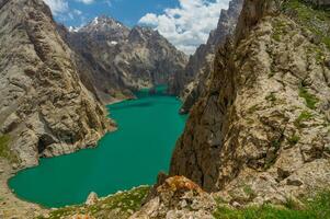 abgelegen kel-su See, umarmt durch gezackt Spitzen, Spiegel das Himmel azurblau Farbton, es ist klar Wasser ein Hochland Oase gegen das Stark, imposant Schönheit von das Umgebung bergig Wildnis Terrain. foto