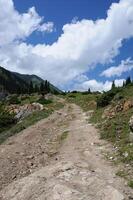 Schmutz Straße, Berge und Gletscher, Kirgistan. Abenteuer reisen, Hinterland. Wandern Pfad, Senke Boden. Einsamkeit, Erholung. draussen, Wandern, Camping. Tourismus, Rucksackreisen und alpin Landschaft foto