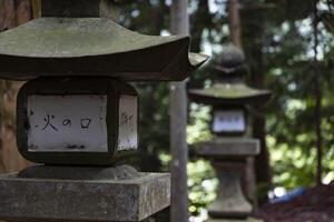 alt Stein Laternen beim japanisch alt Schrein beim das Landschaft schließen oben foto