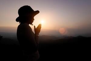 Person Hände öffnen Palme oben Verehrung. Silhouette von Gebet Frau Anbetung Gott im das Morgen mit Sonnenaufgang Himmel Hintergrund. Gott Portion bereuen katholisch. foto